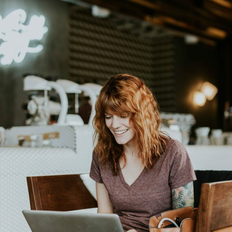 Ginger haired woman happy receiving online therapy